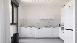 Una cocina moderna con armarios blancos, lavavajillas y microondas.