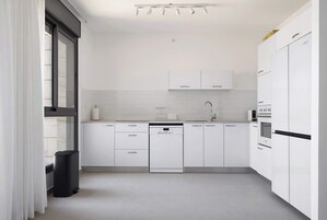 Cozinha moderna com armários brancos, lava-louças e micro-ondas.