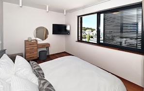 A bedroom with a bed, a dresser, a mirror, a TV, and a window with blinds. - Awesome home in Primosten (Primosten)