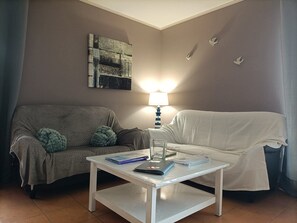 A living room with two couches, a coffee table, a lamp, and a wall art piece. - Cottage 'Le Vieux Chêne' with Shared Pool, Shared Terrace and Wi-Fi (Saint-Valérien)