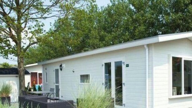 Un bâtiment moderne, de plain-pied, doté d’un toit plat, de grandes fenêtres et d’un chemin piétonnier pavé.