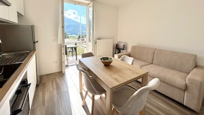 A modern kitchen with a built-in oven and a dining area with a wooden table and chairs.
