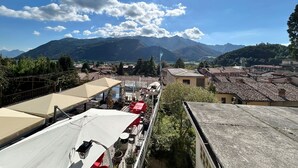 A terrace with outdoor seating, a mountain backdrop, and a clear sky.