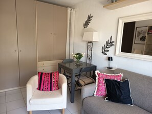 Ein Wohnzimmer mit Sofa, Sessel, Tisch und Wanddekoration.