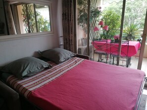 Ein Bett mit Kissen, einer gestreiften Decke und einer rosa Tagesdecke.