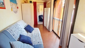 A room with a bed, a wardrobe, a door leading to a balcony, and a wall with a picture.