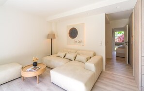 Ein modernes Wohnzimmer mit einer Couch, einem Beistelltisch, einer Lampe und einem Wandbild.