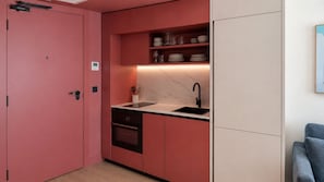 A compact kitchen with a built-in oven, a sink, and a marble countertop. - SUIO Alcobendas (Alcobendas)
