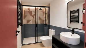 Un bagno moderno con cabina doccia, WC e lavandino.