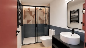 Ein modernes Badezimmer mit Duschkabine, Toilette und Waschbecken.