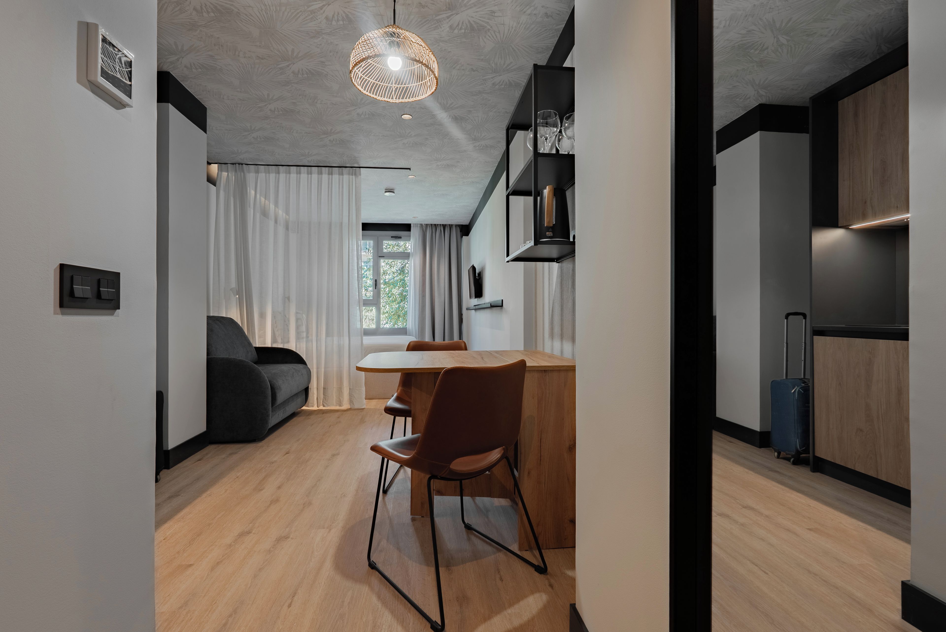 A modern interior with a dining area, a sofa, and a kitchen.