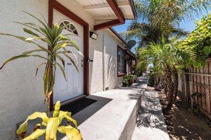 A house with a white door, a small porch, and a pathway leading to the entrance. - Long Beach 2BR - Near Beach, Driveway Parking (Long Beach)