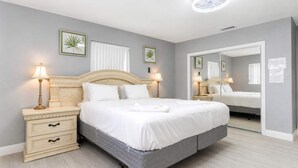 Ein ordentlich eingerichtetes Schlafzimmer mit einem Bett, Nachttischen und Wandlampen.