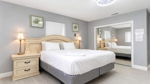 A neatly arranged bedroom with a bed, bedside tables, and wall-mounted lamps. - Hollywood 3BR - Private Pool & Fire Pit (Hollywood)