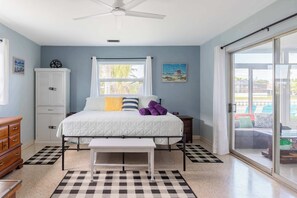 A bedroom with a bed, a bedside table, a wardrobe, a ceiling fan, a window with curtains, and a view of the outside. - ‼️Apollo Beach Waterfront - Boat Slip & Patio (Apollo Beach)