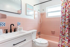 Une salle de bain équipée d’un lavabo, de toilettes, d’une baignoire et d’une douche.