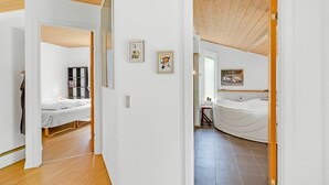 Un interior moderno con un dormitorio, baño y una pequeña zona de estar.