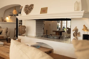 A living room with a fireplace, a coffee table, and a sofa. - MAS DE DARD, Provence Estate, Heated Pool,Pickleball ans Private Lagoon,12 rooms (Saintes-Maries-de-la-Mer)