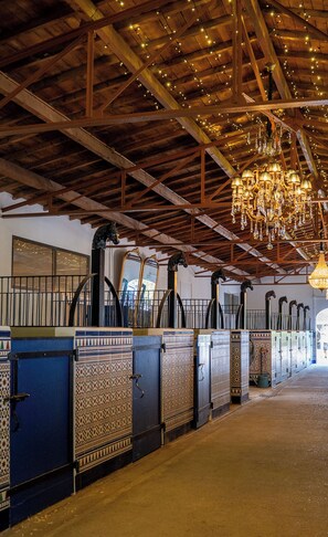 Un intérieur chaleureux avec des poutres en bois, un lustre et des statues de chevaux.