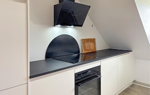 A modern kitchen with a black countertop, white cabinetry, and a built-in oven. - 4 bedroom nice home in Haderslev (Haderslev)