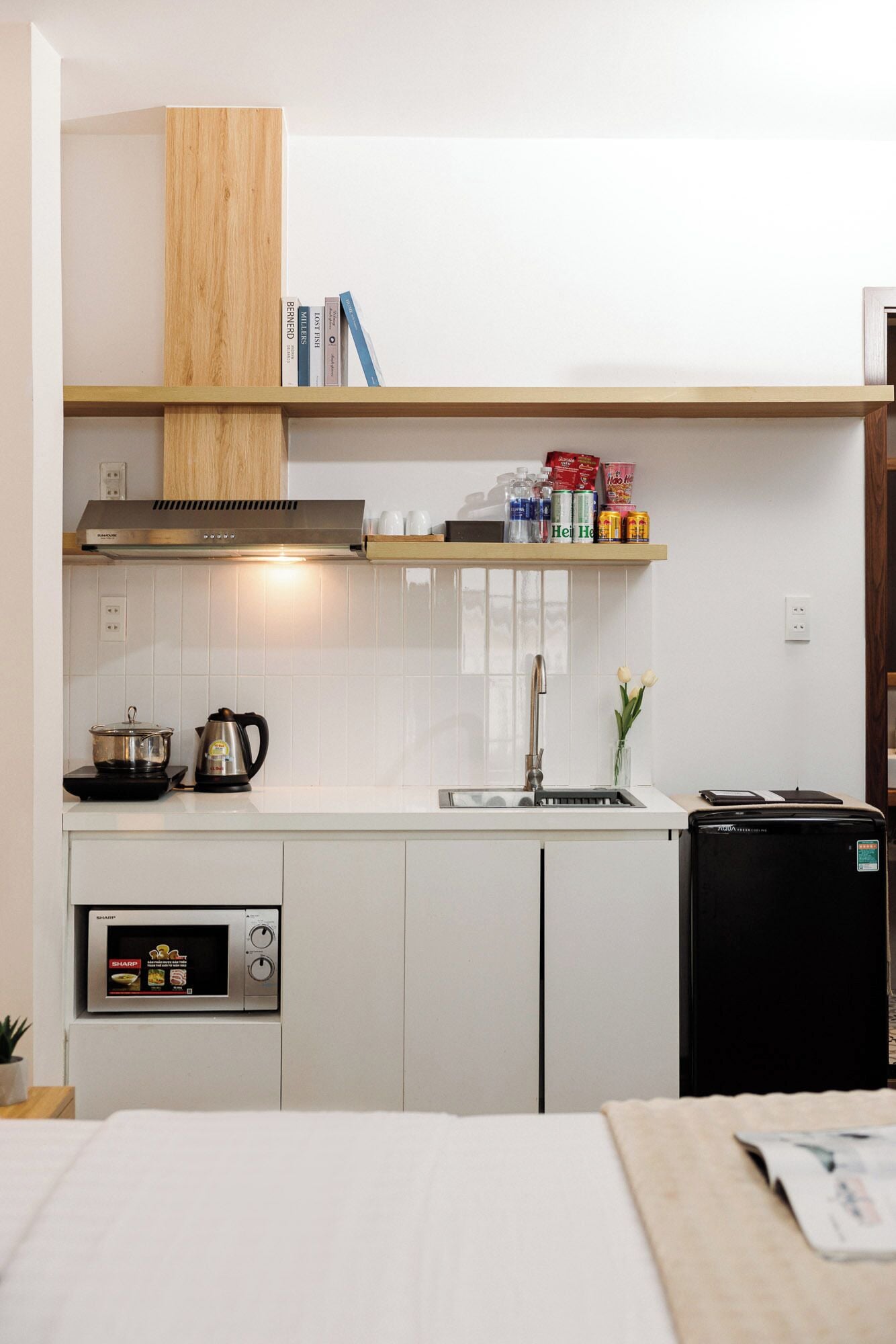 Une cuisine compacte équipée d’un four à micro-ondes, d’une bouilloire et d’un petit réfrigérateur.