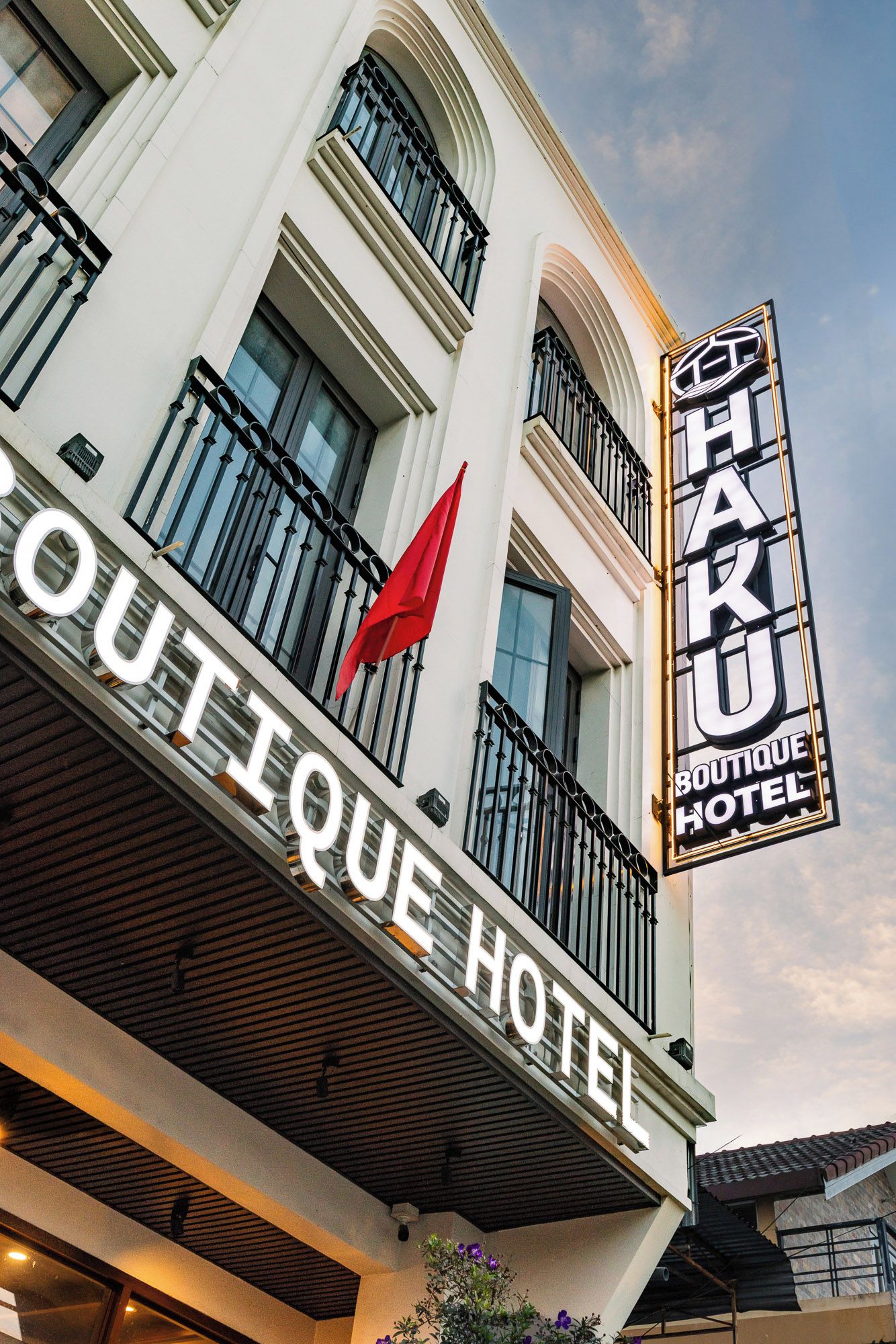 A hotel sign with 'BOUTIQUE HOTEL' and a red flag on the balcony.