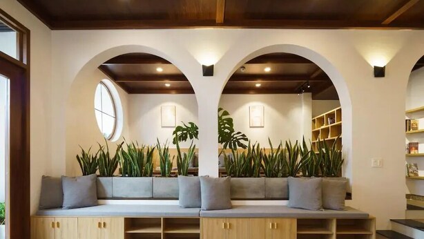 A seating area with a sofa, wooden cabinets, and potted plants. - HAKU Boutique Hotel Da Lat - Ngo Quyen (Cam Ly - Da Lat)