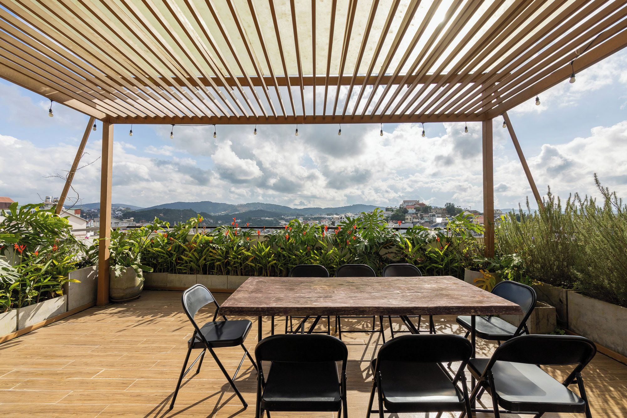 Une terrasse extérieure dotée d’une pergola en bois, d’une table et de chaises.