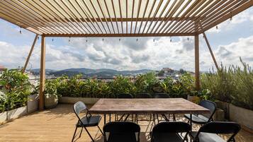 Une terrasse extérieure dotée d’une pergola en bois, d’une table et de chaises.