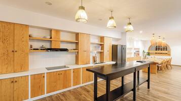Cocina moderna con gabinetes de madera, una isla central e iluminación colgante.
