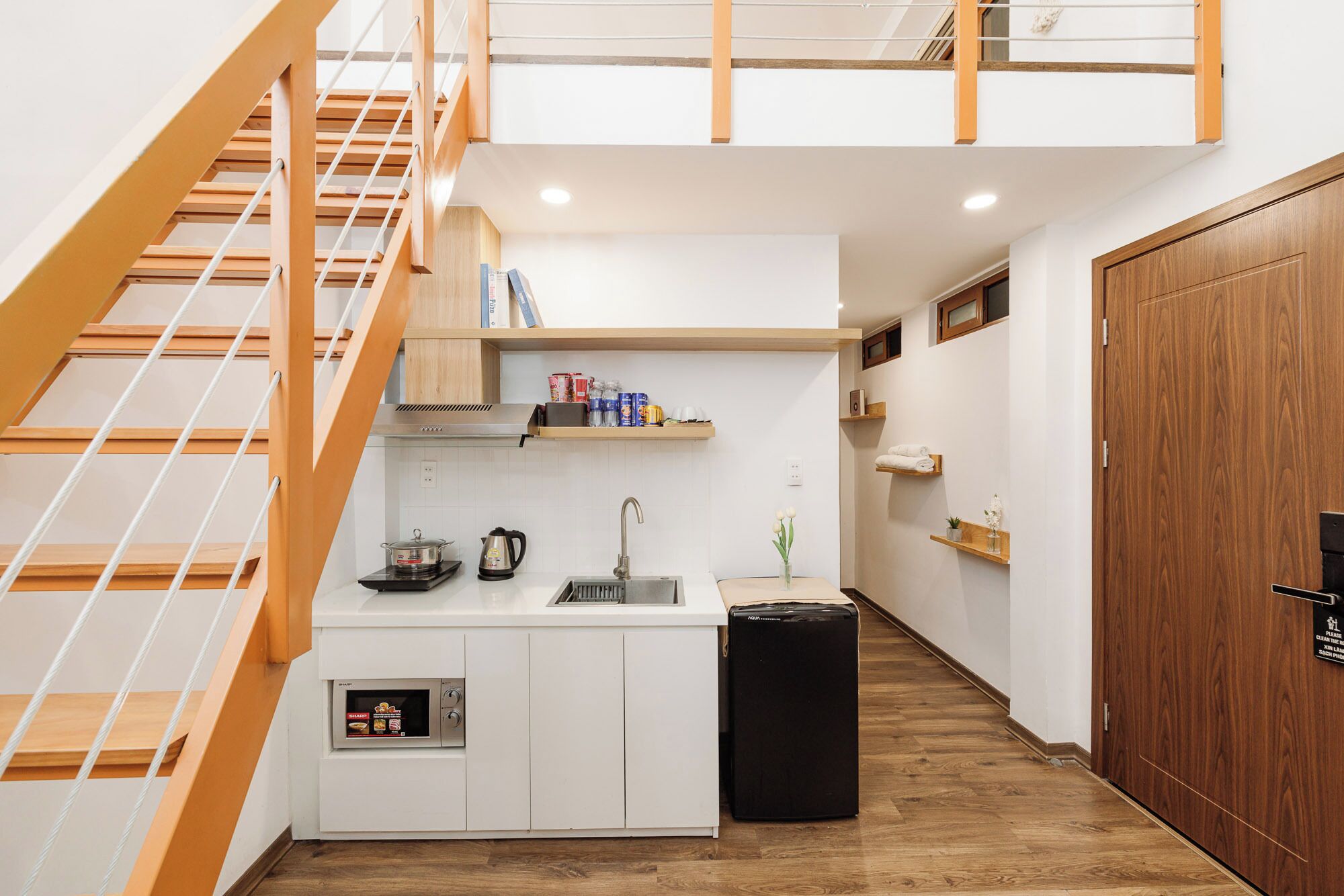 A compact kitchen with a built-in oven, a sink, and a small refrigerator.