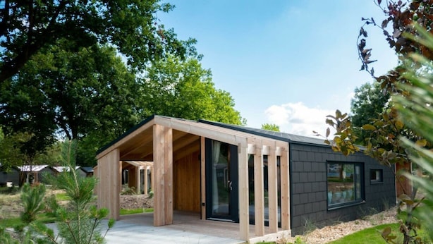 A modern house with a wooden deck, large windows, and a garden. - Panorama Cottage 4 (Kaatsheuvel)