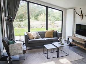 Ein modernes Wohnzimmer mit einer Couch, einem Couchtisch und einem Fernseher.