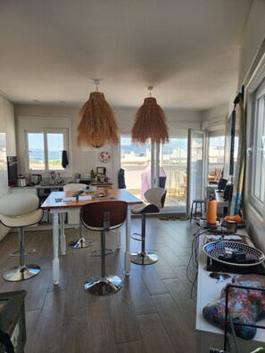 Eine moderne Küche mit Essbereich, großen Fenstern und Meerblick.