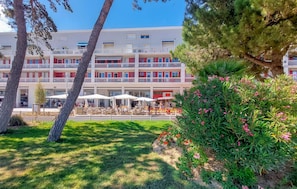 Ein Hotel mit Poolbereich, Außenbereich zum Sitzen und einem Blumengarten.