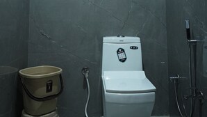 Un baño con inodoro, ducha y lavamanos.