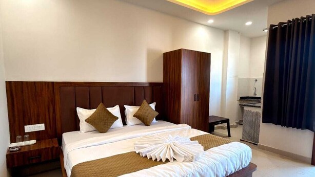 Una habitación de hotel con una cama grande, un armario, un escritorio y un ventilador de techo.