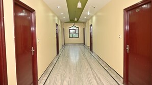 A hallway with wooden doors, a green ceiling, and a window at the end. - 45 room  family room and corporate (724)