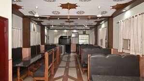 A restaurant with a long counter, multiple seating areas, and a patterned ceiling. - 45 room  family room and corporate (724)