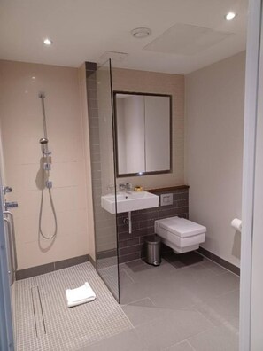 Ein modernes Badezimmer mit Dusche, Waschbecken und Toilette.