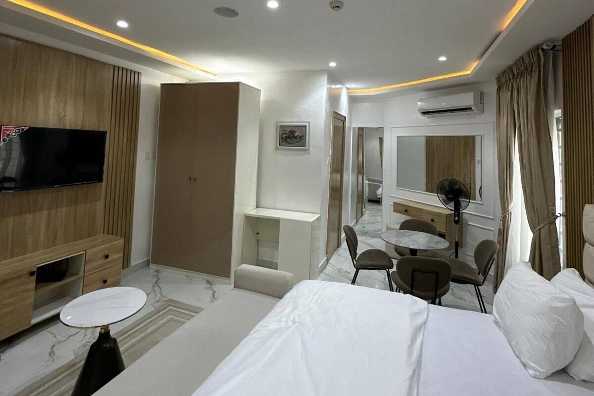 Hotelkamer met een bed, televisie, bureau, stoel, spiegel en airconditioning.