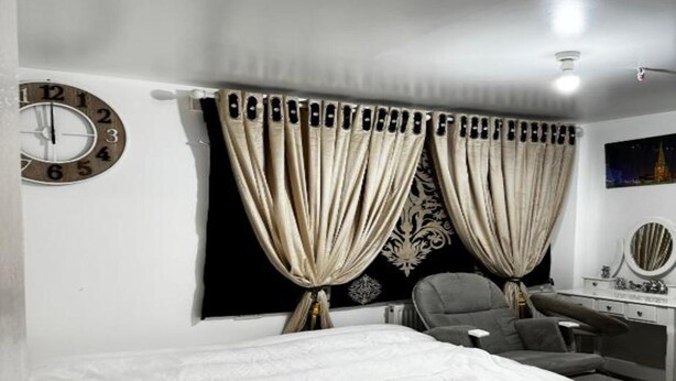 A bedroom with a bed, a chair, a desk, and curtains. - Standard Double Room (Bolton)