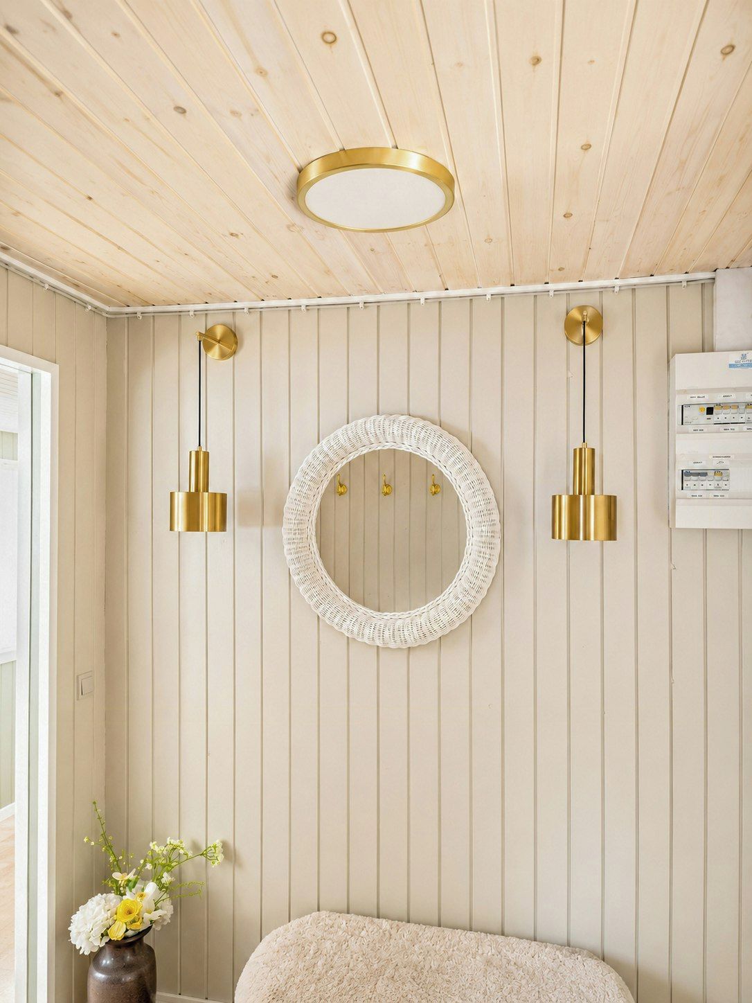 A room with a wooden ceiling, a round mirror, and two wall-mounted lights.