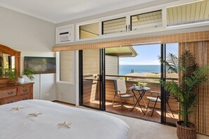 A hotel room with a balcony, a bed, a dining area, and a view of the sea. - Two-Story Ocean View Retreat Steps from Pool & Beaches -KRV 915 (Lahaina)