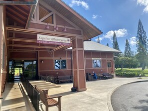 A building with a sign reading "Kapalua Village Center" and "Bay Golf." - Two-Story Ocean View Retreat Steps from Pool & Beaches -KRV 915 (Lahaina)