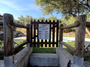 A wooden gate with a sign indicating pool rules and a height restriction of 430 cm. - On Kiniperu (Tasonis)