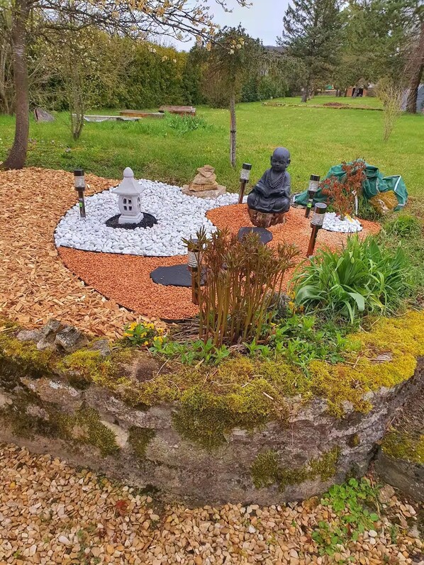 A garden with a stone lantern, a statue, and a small pagoda. - Vacation Rental with Spa and Hammam – Relaxation and Nature in the Heart of the Forêts National Park (Recey-sur-Ource)