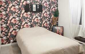 A bedroom with a bed, a wall-mounted TV, a framed picture, and a plant. - Awesome apartment in Marseille (Marseille)