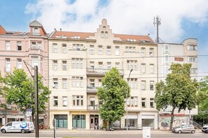 A multi-story building with a classic architectural style, featuring a central entrance, balconies, and a flat roof with solar panels. - Exclusive Cube loft near the main train station (Berlin)