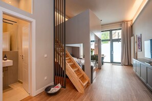 Ein modernes Interieur mit einer Holztreppe, einer Küchenzeile und einem Essbereich.